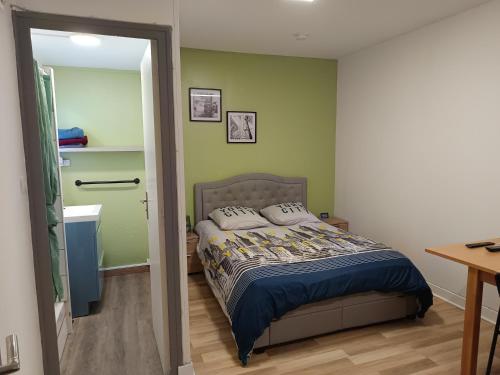 a bedroom with a bed in a room with green walls at Studio blanctout équipé wifi in Le Creusot