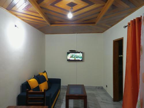 a living room with a couch and a tv at RÉSIDENCE MEUBLÉE CYMAT in Douala