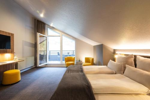 a hotel room with two beds and a large window at Uferdeck - Boutique Hotel in Traben-Trarbach