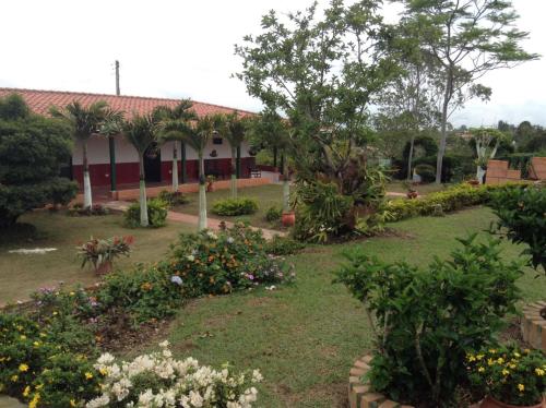 a garden in front of a building with flowers at Villa Liliana Lodge Mesa de los Santos in Los Santos
