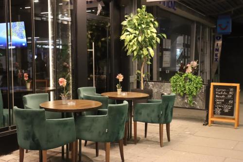 two tables and chairs in front of a restaurant at Hotel Macedonia Square in Skopje