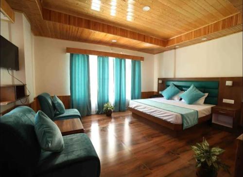 um quarto com uma cama e um sofá num quarto em Hotel Royal hills em Ujjain