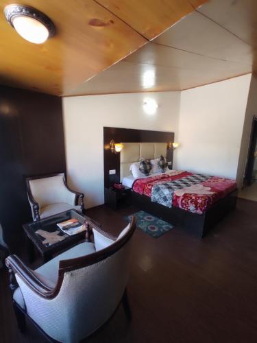 um quarto com uma cama, um sofá e uma cadeira em Hotel Royal hills em Ujjain