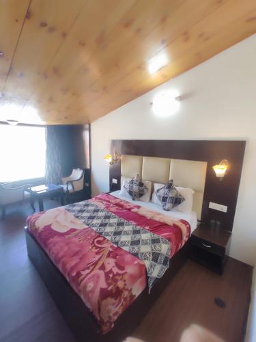 um quarto com uma cama grande e um cobertor vermelho em Hotel Royal hills em Ujjain