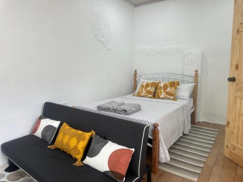 a bedroom with a bed and a couch at Cozy Studio Tobago in Scarborough