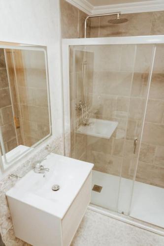 a bathroom with a white sink and a shower at Picasso - Spacious Apartment in Old Town Nerja in Nerja