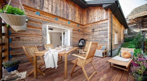 un patio con mesa y sillas en una pared de madera en Lux Constance Cottage, en Tylmanowa