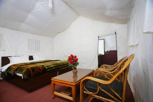 1 dormitorio con 1 cama, 1 mesa y 1 silla en Nubra Escapes, en Hundar