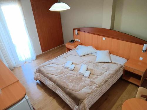 a bedroom with a large bed with two white pillows at Hotel Liberty in Mesolongion