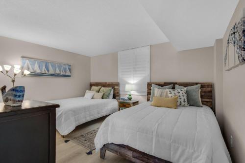 a bedroom with two beds and a table at Dolphin Point #602A in Destin