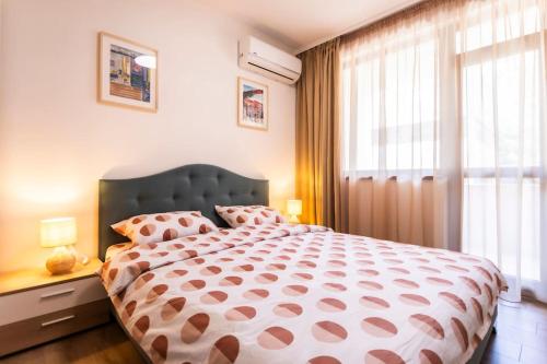 a bedroom with a large bed with a large window at Summer Vibes Apartment in Burgas