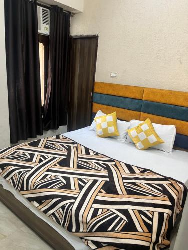 Schlafzimmer mit einem Bett mit einer schwarzen und weißen Bettdecke in der Unterkunft Arora classic guest house in Amritsar