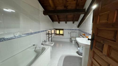 a bathroom with two toilets and a tub and a sink at El Molino de Cicera in Cicera