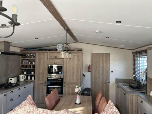 a kitchen with a table and chairs in a room at KMH Caravans at Flamingo Land in Kirby Misperton