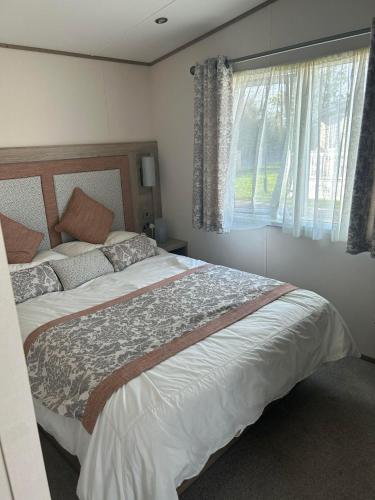 a bedroom with a large bed and a window at KMH Caravans at Flamingo Land in Kirby Misperton