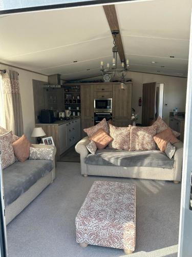 a living room with two couches and a table at KMH Caravans at Flamingo Land in Kirby Misperton