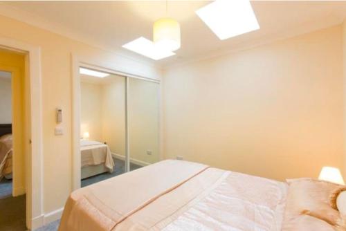 um quarto com uma cama e um espelho em Spacious 2-Bedroom Condo With Free Parking On Site em Montrose