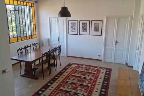 een eetkamer met een tafel en stoelen en een tapijt bij Villa Luigia in Leggiuno