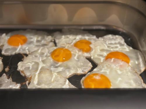 three eggs are cooking in a pan on a stove at Liberty in Blankenberge