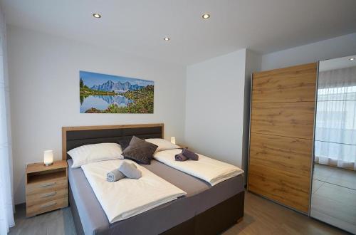 una camera con un letto con due cuscini di Apartment Lina & Lejs a Gröbming
