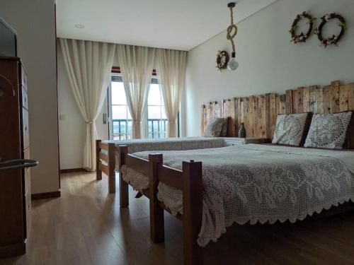 a bedroom with two beds and a large window at Casa das Leiras - Mondim de Basto in Mondim de Basto