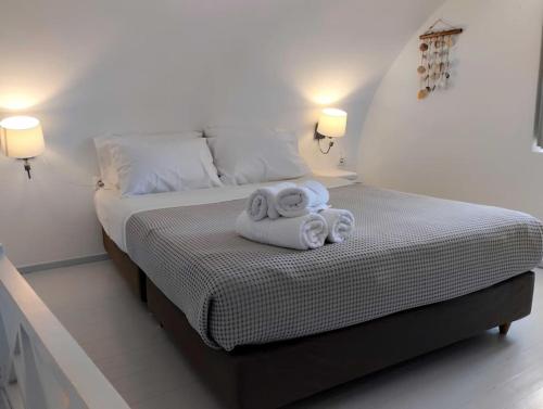 ein Schlafzimmer mit einem Bett mit Handtüchern darauf in der Unterkunft ENDLESS SUMMER in Oia