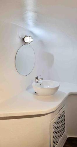 a white bathroom with a sink and a mirror at ENDLESS SUMMER in Oia