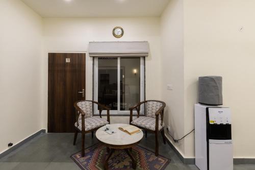 Zimmer mit 2 Stühlen, einem Tisch und einem TV in der Unterkunft Heart of the City Homestay by Rashmi in Jaipur