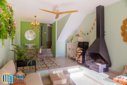 uma sala de estar com lareira e paredes verdes em Casa Ànima em Platja d'Aro