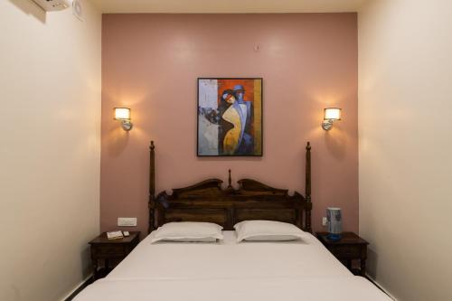 1 dormitorio con 1 cama con una pintura en la pared en Heart of the City Homestay by Rashmi en Jaipur