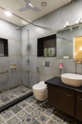 a bathroom with a toilet and a sink and mirror at Heart of the City Homestay by Rashmi in Jaipur