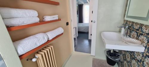 een badkamer met een wastafel, een toilet en handdoeken bij Arte in piazza Agrigento centro in Agrigento