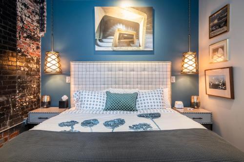 a bedroom with a large bed with blue walls at 80 Lex 203 Eclectic Industrial Apt in Asheville