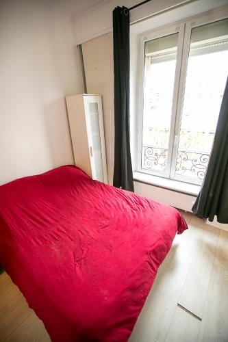 - un lit rouge dans une chambre avec fenêtre dans l'établissement 2 pièces moderne Victor Hugo/Trocadero, à Paris