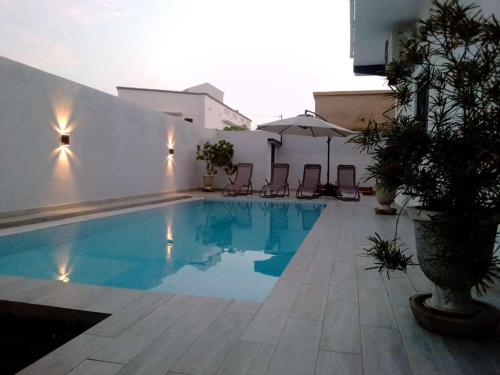 uma piscina no meio de um edifício em Villa Fama em Mbour