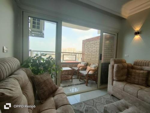 ein Wohnzimmer mit 2 Sofas und einem Balkon in der Unterkunft Charming Seaview Condo in Gleem in Alexandria
