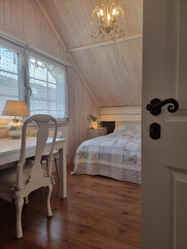 a bedroom with a desk and a bed and a chandelier at Countryhouse Lake Attersee - Traumhaft schöne Lage - Bezauberndes Hideaway in Unterach am Attersee