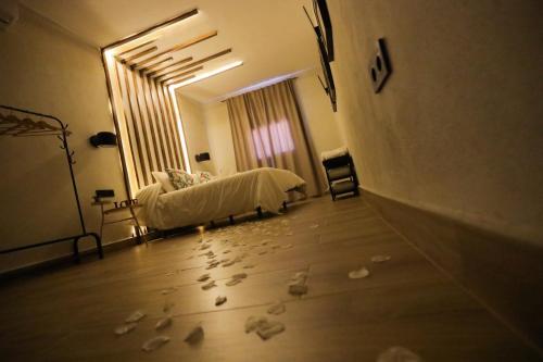 a bedroom with a bed with footprints on the floor at Azahara Casa Boutique in Arcos de la Frontera