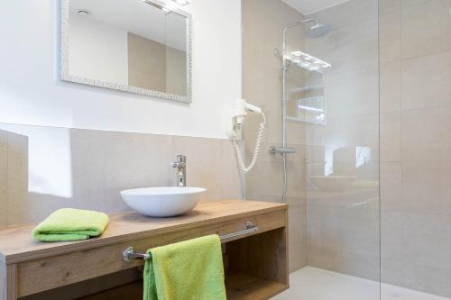 a bathroom with a sink and a glass shower at Landhaus Bergland in Obsteig