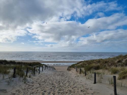 a sandy path leading to the ocean on a beach at Rembrandts beach view in Zandvoort