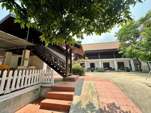 a building with a white fence and stairs in front at Residence Boutique Hotel in Luang Prabang