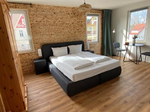um quarto com uma cama grande e uma parede de tijolos em Alte Apotheke, Apartment Nr. 3 / Thymian em Baiersbronn