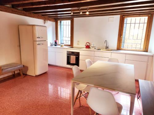 a kitchen with a table and a white refrigerator at Lo Squero apt in Venice