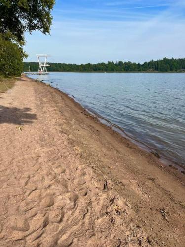 a chair sitting on the shore of a body of water at Charmigt torp på höjden in Gamleby