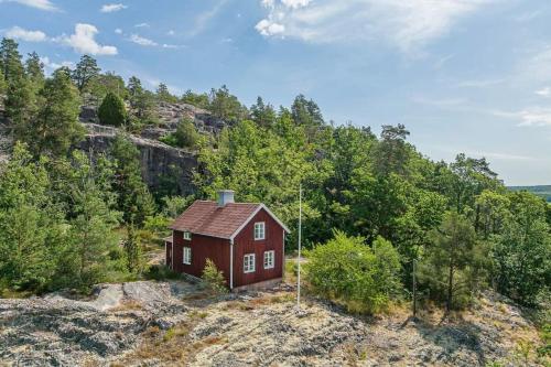 una pequeña casa roja en la cima de una colina en Charmigt torp på höjden, en Gamleby