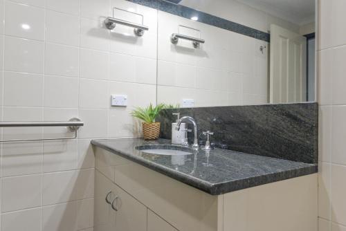 a bathroom with a sink and a mirror at Great Location! Darling Harbour Superb 2BR Apt in Sydney