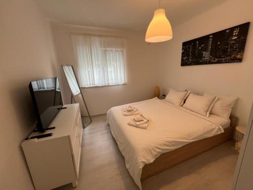 a small bedroom with a bed and a television at Luxe City in Rijeka