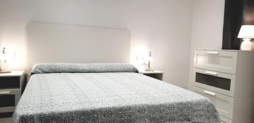 ein weißes Schlafzimmer mit einem Bett und einer Kommode in der Unterkunft Villa Crisantemos in Nerja