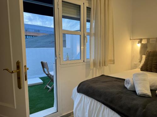 een slaapkamer met een bed en een raam met uitzicht bij Casa Boutique Plaza de Armas -Townhouse- in Sevilla