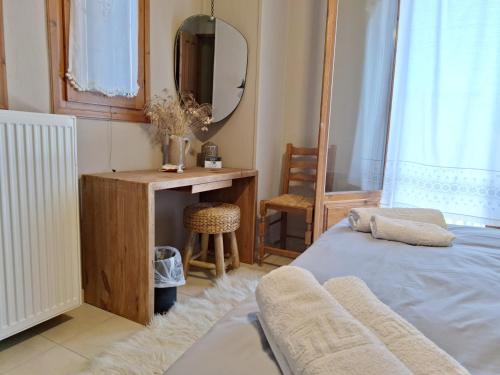 a bedroom with a bed and a desk and a mirror at Skourgias Rooms in Kala Nera